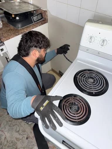 Technician repairing an electric coil stove